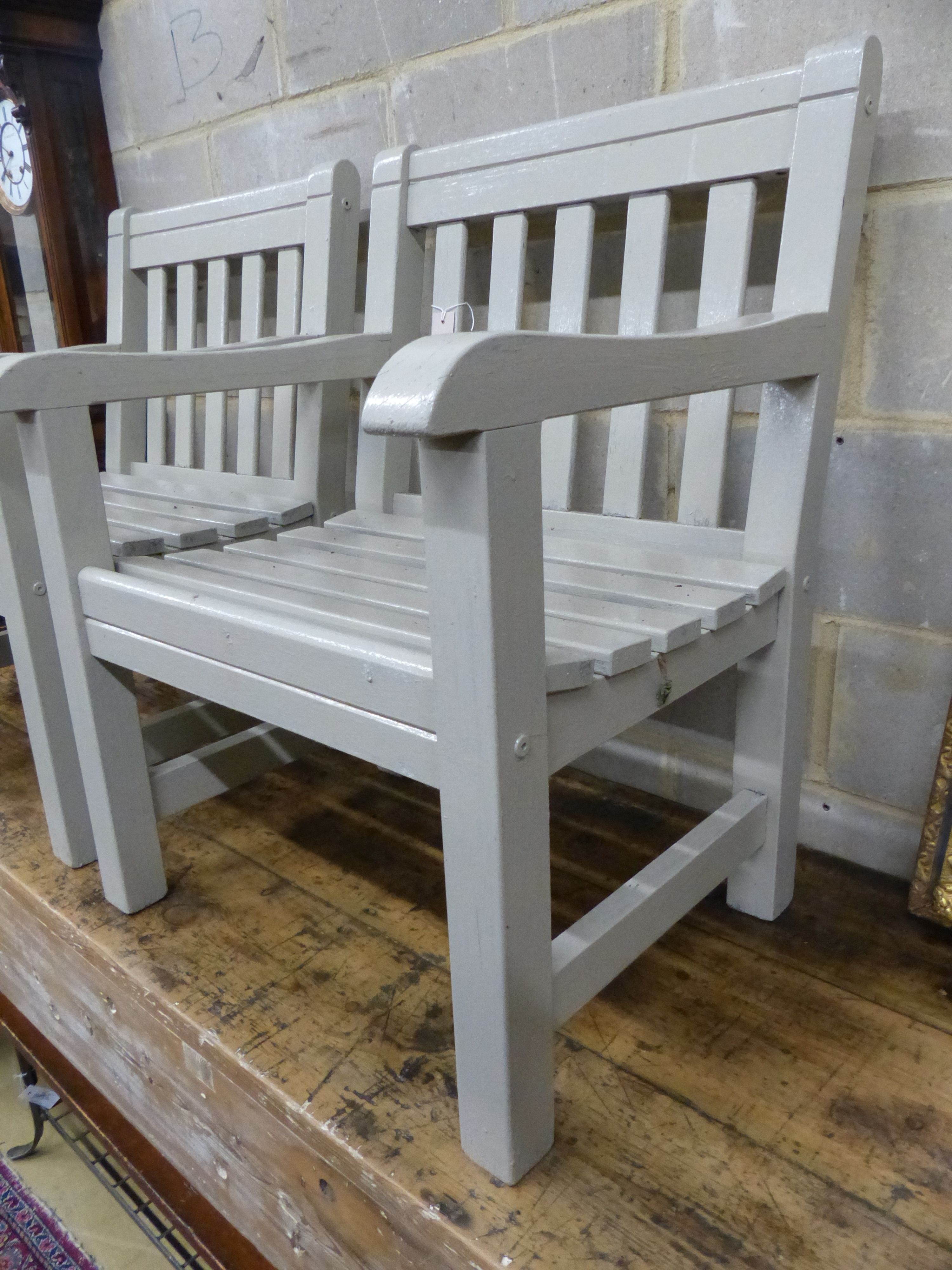 A pair of painted teak garden armchairs, W.65cm D.61cm H.88cm